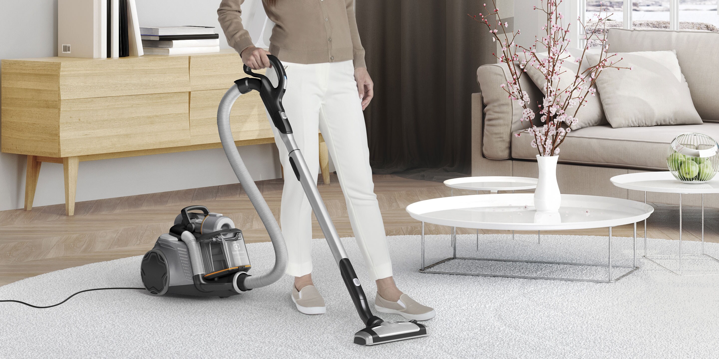 Eine Frau, die ein Wohnzimmer mit dem UltraFlex Staubsauger reinigt