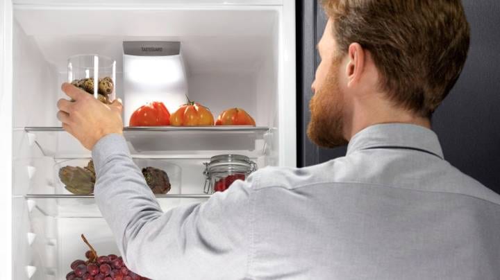Ein Mann, der einen Kühlschrank öffnet