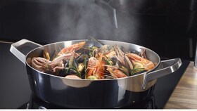 De la vapeur sortant d'une casserole vers une hotte