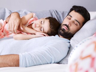 Ein Elternteil mit Kind, die zusammen in ihrem frischen und kühlen Zuhause ein Buch lesen
