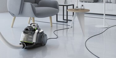 Someone using the Electrolux UltraFlex Green's extra long cord to effortlessly clean a living room