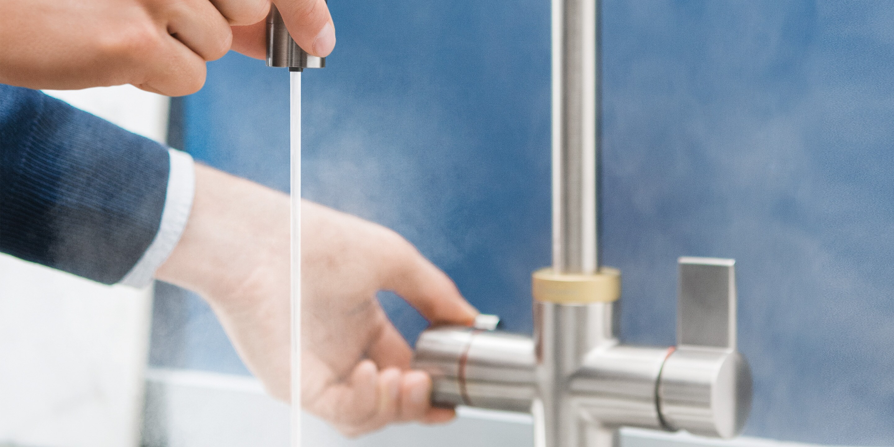 Ein Mann, der den isolierten Auslauf der Electrolux QuickSource Armatur berührt