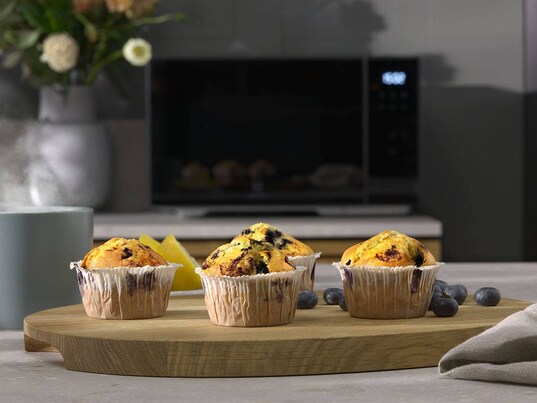 Muffins vor einer schwarzen Electrolux Mikrowelle