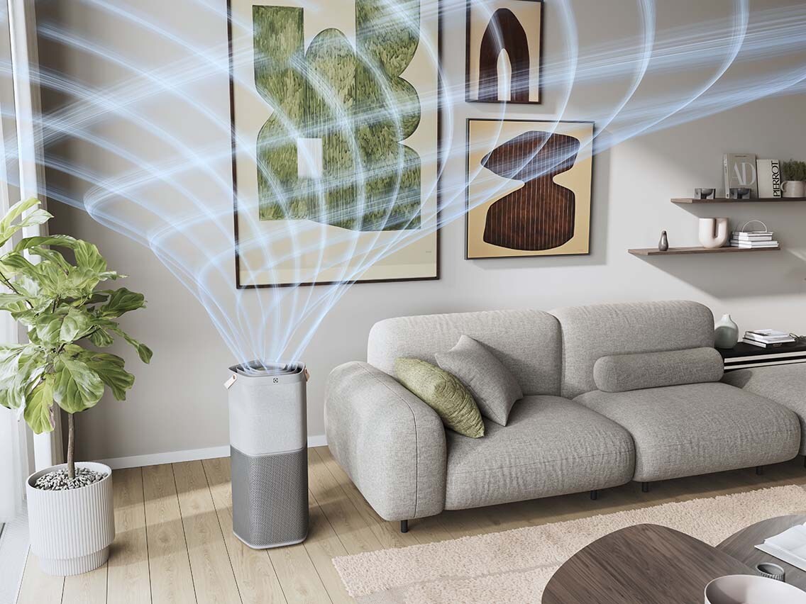 Un purificateur d'air dans un salon, à côté d'un canapé