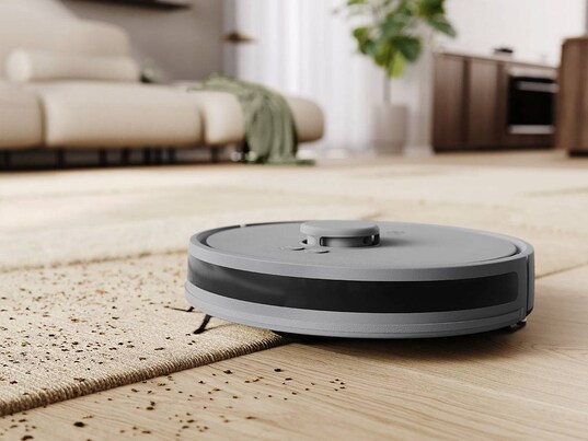 Un robot aspirateur rond sur une surface de tapis