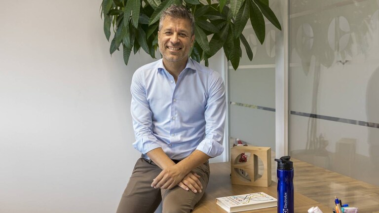 Un employé d'Electrolux assis sur un banc rit à la caméra