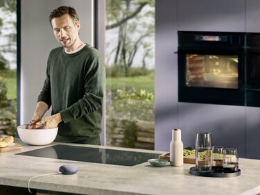 Hands in bowl and Google Assistant on countertop